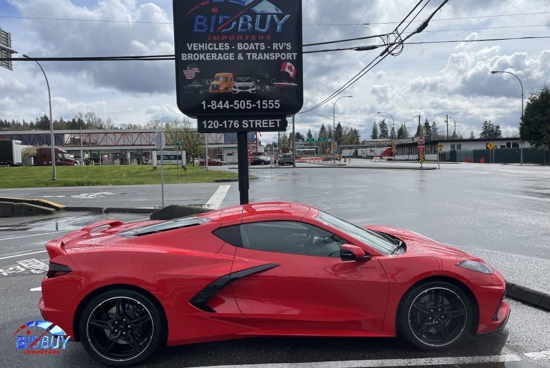 The advertisement for bidbuy company in Blaine, Washington is visible behind a red sport car